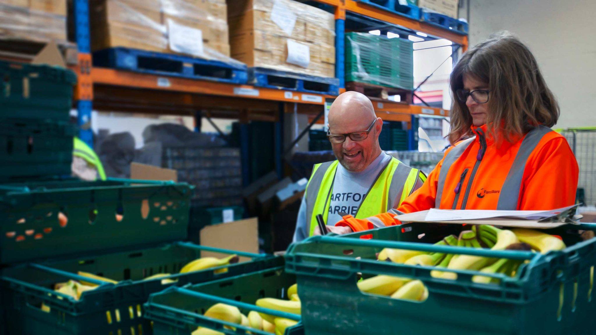 A team of volunteers packs food parcels in a warehouse.
