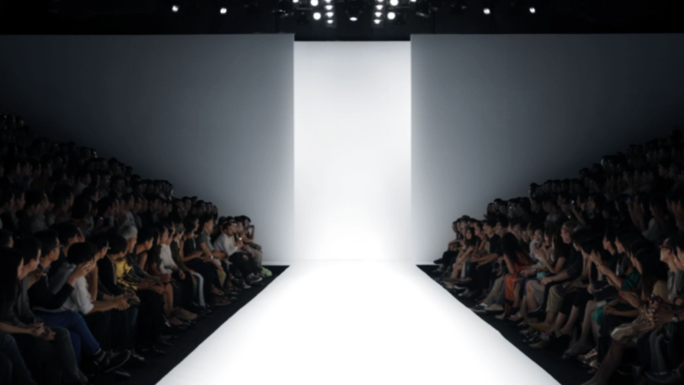 A fashion show with an empty catwalk and a full audience