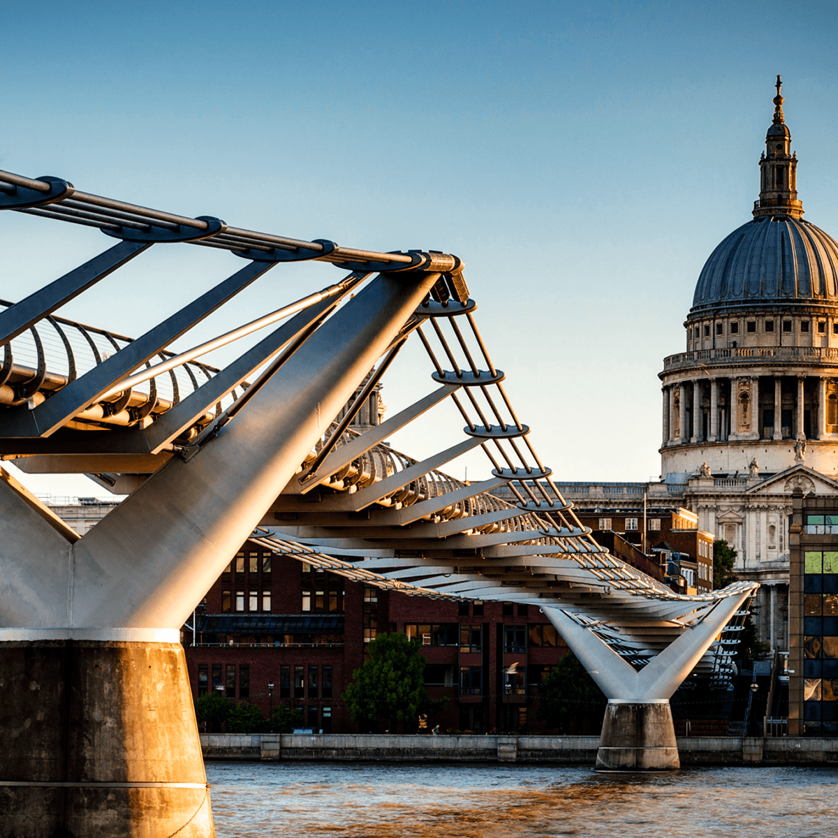 An image of St Paul's cathedral taken from across the river Thames with the millennium bridge in the foreground