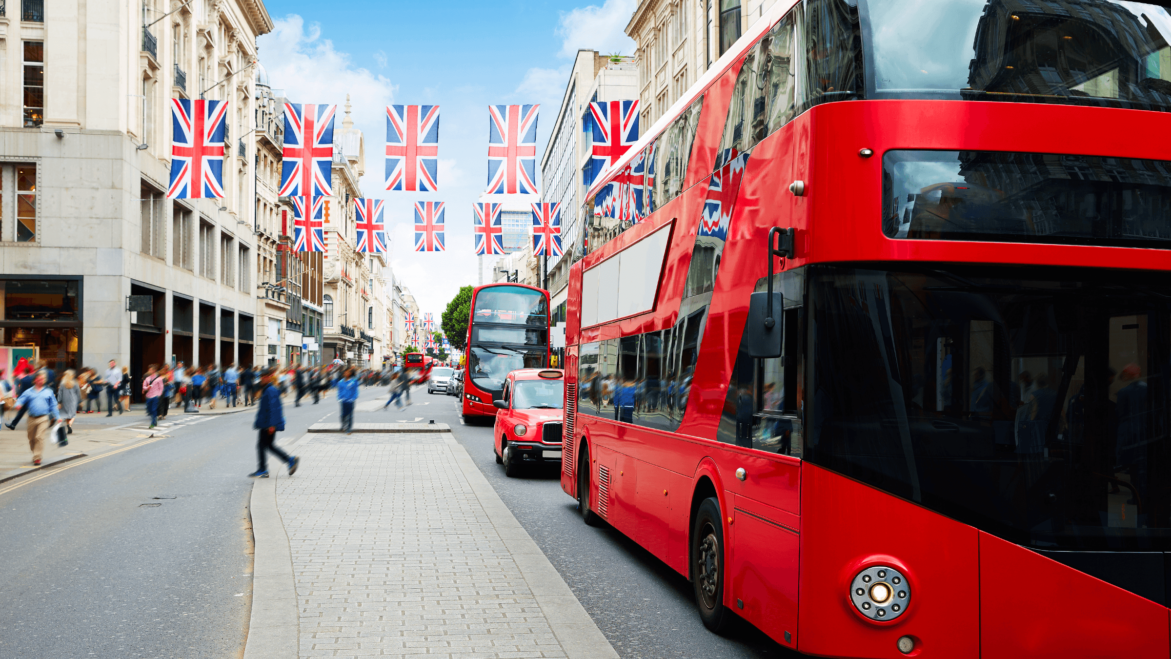 a red london bus driving through oxford street