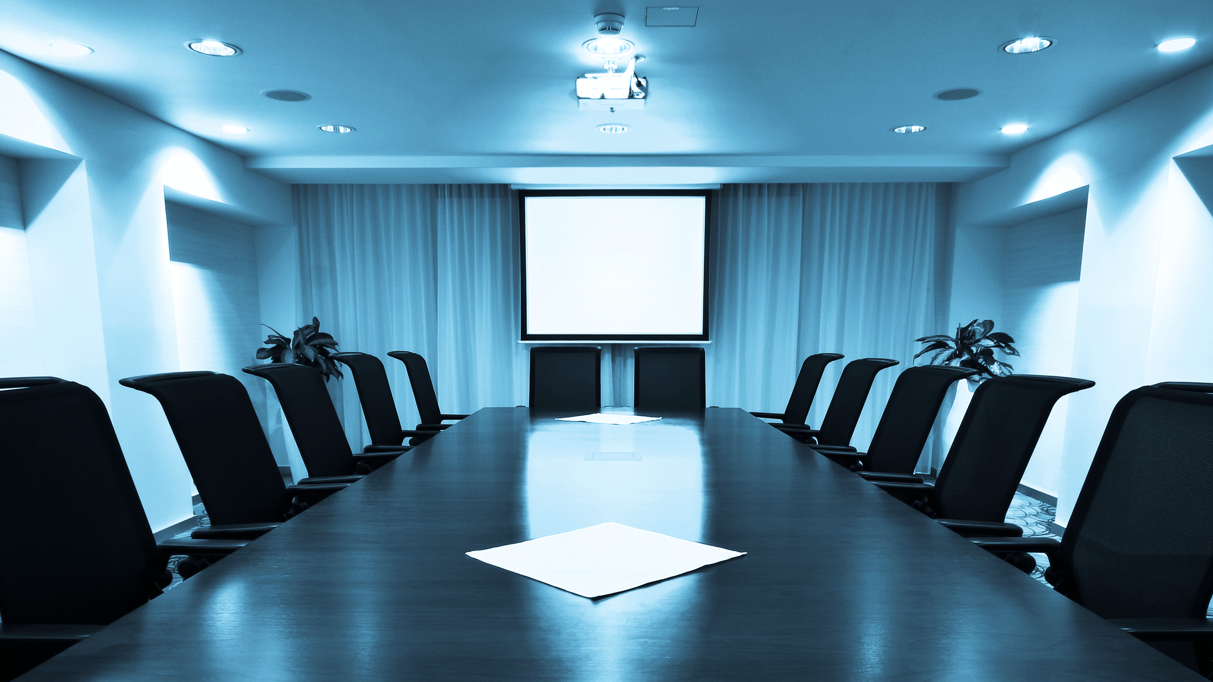 Picture of a boardroom with chairs around the table